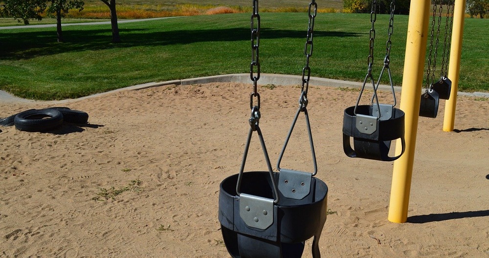 An image of several swing seats at a park.