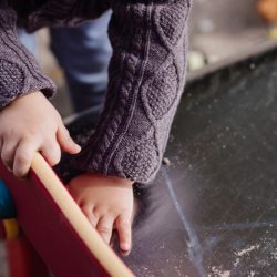 An image showing a child playing at the end of a steel bottomed slide.