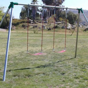 An image of a swing set with two red swings attached.