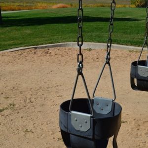An image of several swing seats at a park.