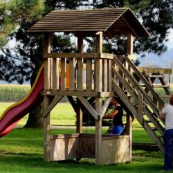 An image of parents and children around a playset with a slide on it.